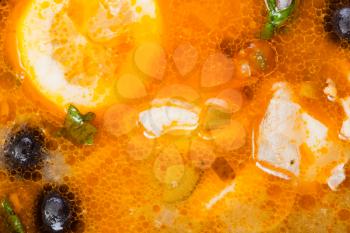 food background - surface of Solyanka russian traditional spicy and sour soup with fish close up