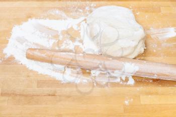 flour, rolling pin and kneading dough on wooden table