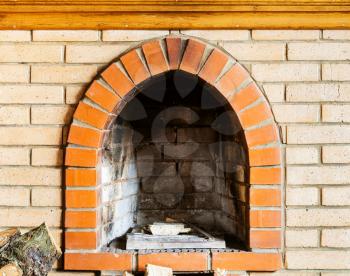 fire-box of not kindled brick fireplace indoor