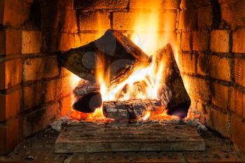 burning wood in fire-box of fireplace in country cottage