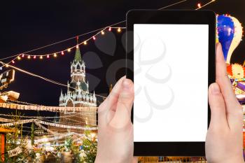 travel concept - tourist photographs Christmas Fair on Red Square in Moscow in night on tablet pc with cut out screen with blank place for advertising, Russia