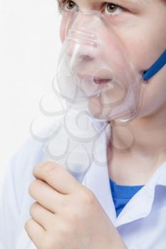 medical inhalation treatment - girl breathes with face mask of modern jet nebulizer