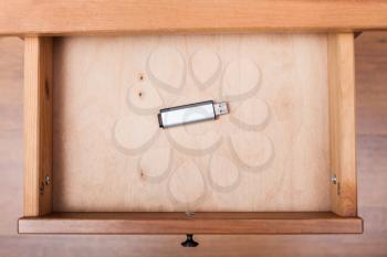 top view of flash drive in open drawer of nightstand