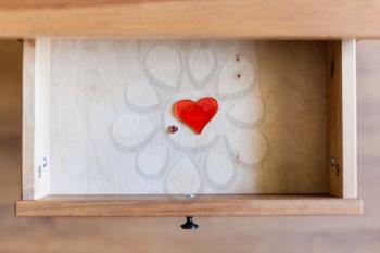 above view of little and big glass hearts in open drawer of nightstand