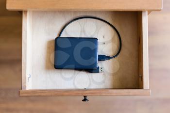 above view of external hard drive in open drawer of nightstand