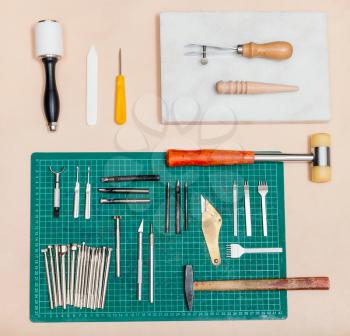 above view of various tools for leatherwork on natural leather surface
