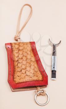 Leathercraft - new hand made carved leather key case and swivel knife on leather surface