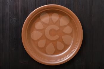 top view of one brown plate on dark brown table