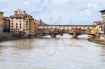 travel to Italy - dirty water of Arno river and view of Ponte Vecchio (Old Bridge) in Florence city in autumn