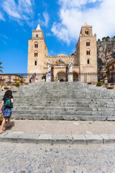 CEFALU, ITALY - JUNE 25, 2011: people near gate in Duomo di Cefalu in Sicily. Cathedral - Basilica of Cefalu was erected in 1131 in the Norman architectural style
