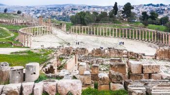 Travel to Middle East country Kingdom of Jordan - above view of The Oval Forum and columns of Cardo Maximus path in Jerash (ancient Gerasa) town in winter