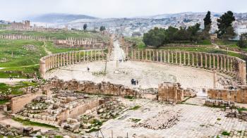 Travel to Middle East country Kingdom of Jordan - above view of The Oval Forum and Cardo Maximus path in Jerash (ancient Gerasa) town in winter