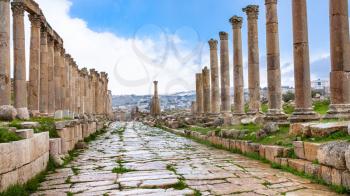 Travel to Middle East country Kingdom of Jordan - wet Cardo Maximus road in Jerash (ancient Gerasa) town in winter in rain