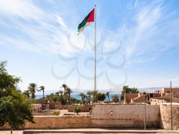 Travel to Middle East country Kingdom of Jordan - Flag of the Arab Revolt over Mamluk Castle in Aqaba city
