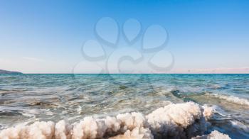 Travel to Middle East country Kingdom of Jordan - crystalline salt close up on shore of Dead Sea in sunny winter day