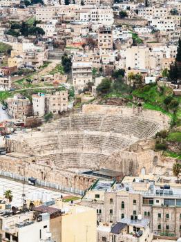 AMMAN, JORDAN - FEBRUARY 18, 2012: above view of ancient Roman theater in Amman town from citadel in winter. The Amphitheatre was built the Roman period when the city was known as Philadelphia