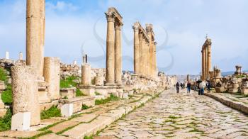 JERASH, JORDAN - FEBRUARY 18, 2012: people walk on Cardo Maximus road in winter. Greco-Roman town Gerasa (Antioch on the Golden River) was founded by Alexander the Great or his general Perdiccas