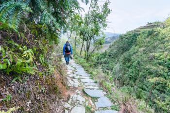 travel to China - tourist on path on mountain slope in Dazhai country of Longsheng Rice Terraces (Dragon's Backbone terrace, Longji Rice Terraces) in spring