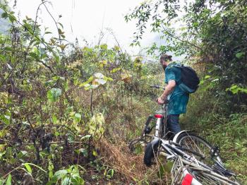 travel to China - bicyclist on overgrown slope of karst mountain in Yangshuo County in spring season