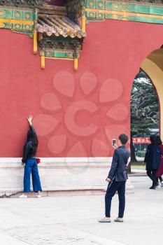 BEIJING, CHINA - MARCH 19, 2017: tourists take photo near gate in Imperial Ancestral Hall public park in Beijing Imperial city in spring. This park is part of Forbidden City green area