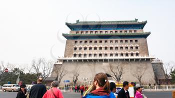 BEIJING, CHINA - MARCH 19, 2017: tourists on street and view of Arrow Tower (Jian Lou, Jianlou, Zhengyangmen Gate) in Beijing in spring. The tower is the ancient building situated on Tiananmen Square