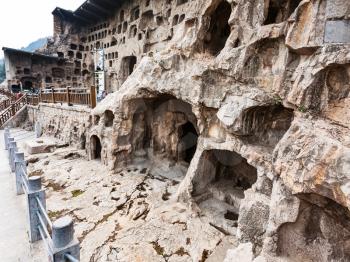 LUOYANG, CHINA - MARCH 20, 2017: caves and Grottoes in rock of West Hill of Chinese Buddhist monument Longmen Grottoes. The complex was inscribed upon the UNESCO World Heritage List in 2000