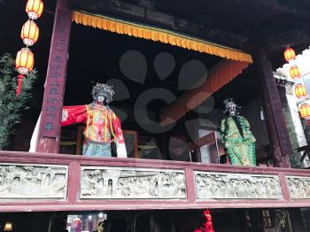XINGPING, CHINA - MARCH 30, 2017: puppets on facade of ancient opera stage in Xing Ping town in Yangshuo county. The town was settled in 265 AD, Xingping is surrounded by great examples of Karst peaks