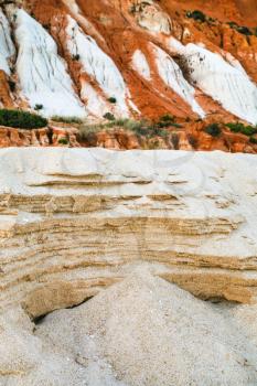 Travel to Algarve Portugal - various sands on slope of sandstone mountain on beach Praia Falesia near Albufeira city in evening