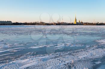view of ice covered Neva river and Peter and Paul Fortress in Saint Petersburg city in March evening