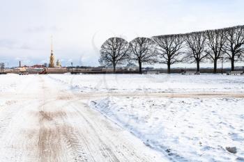 snow-covered garden on Spit of Vasilyevsky Island and view of Peter and Paul Fortress in Saint Petersburg city in march