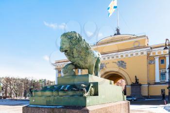 view of bronze statue of Guard lion and old Admiralty building on Admiralty Embankment in Saint Petersburg city in march