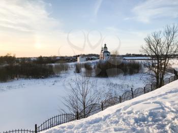 frozen river and view of Church of Elijah the Prophet on Ivanovo Hill (Elijah Church) Suzdal town in winter twilight in Vladimir oblast of Russia