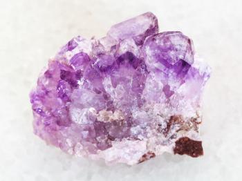 macro shooting of natural mineral rock specimen - raw Amethyst crystal druse on white marble background from Tersky Coast , Kola Peninsula, Russia