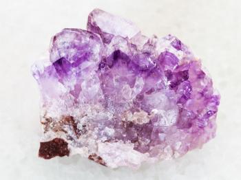 macro shooting of natural mineral rock specimen - rough Amethyst crystal druse on white marble background from Tersky Coast , Kola Peninsula, Russia