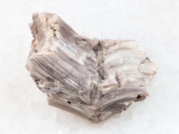 macro shooting of natural mineral rock specimen - rough baryte stone on white marble background from Irkutsk region, Russia
