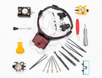 watchmaker workshop - top view of equipments for repairing watch on white background