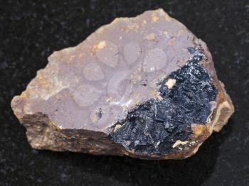 macro shooting of natural mineral rock specimen - goethite aggregates on limonite stone on dark granite background from Olkhinskoye mine, Irkutsk region, Russia