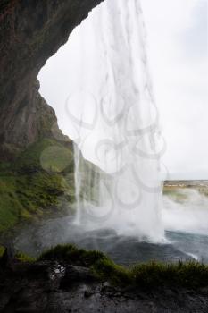 travel to Iceland - wet path in cave of Seljalandsfoss waterfall of Seljalands River in Katla Geopark on Icelandic Atlantic South Coast in september