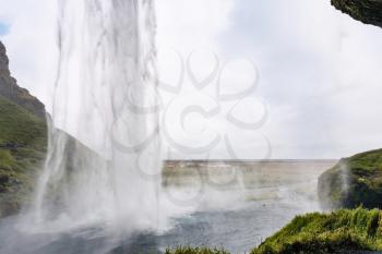 travel to Iceland - view of Seljalandsfoss waterfall from cave in Katla Geopark on Icelandic Atlantic South Coast in september