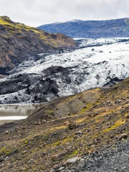 travel to Iceland - volcanic slope and Solheimajokull glacier (South glacial tongue of Myrdalsjokull ice cap) in Katla Geopark on Icelandic Atlantic South Coast in september