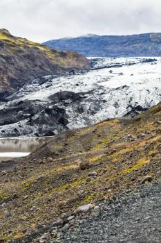travel to Iceland - volcanic slope and view of Solheimajokull glacier (South glacial tongue of Myrdalsjokull ice cap) in Katla Geopark on Icelandic Atlantic South Coast in september