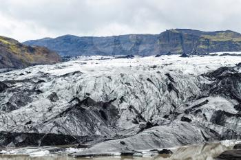 travel to Iceland - tourists on surface of Solheimajokull glacier (South glacial tongue of Myrdalsjokull ice cap) in Katla Geopark on Icelandic Atlantic South Coast in september