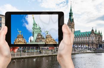 travel concept - tourist photographs Hamburger Rathaus near Binnenalster (Inner Alster Lake) in Hamburg city in Germany in autumn on tablet