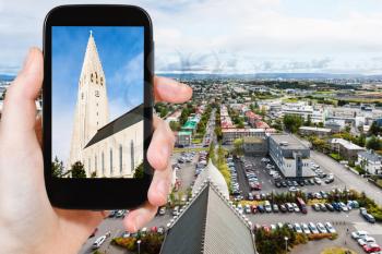 travel concept - tourist photographs Hallgrimskirkja church in Reykjavik city in Iceland in september on smartphone