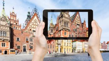 travel concept - tourist photographs Old Town Hall (Rathaus) on Market Square (Rynek) in Wroclaw city on tablet