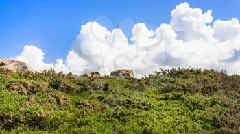 travel to France - blue sky with white cloud over moorland in Ploumanac'h site of Perros-Guirec commune on Pink Granite Coast of Cotes-d'Armor department in the north of Brittany in sunny summer day