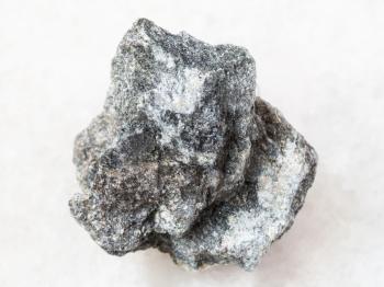 macro shooting of natural mineral rock specimen - raw Soapstone stone ( talc - schist ) on white marble background