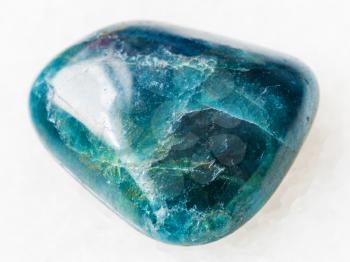 macro shooting of natural mineral rock specimen - tumbled green blue Apatite gemstone on white marble background from Araguaia mine, Brazil
