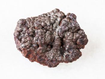 macro shooting of natural rock specimen - rough Goethite stone (brown iron) on white marble background from Tharsis, Spain