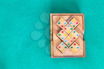 top view of wooden box with puzzle on green baize table with copyspace